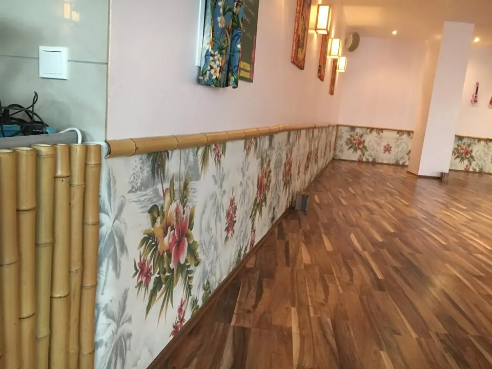 Detail: Bambusleiste, Blumen-Tapete und Holzboden im Hawaii-Stil