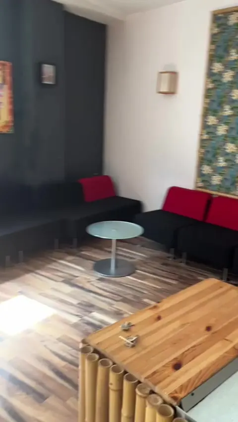 Lounge mit schwarzen Sofas und roten Kissen im Eingangsbereich